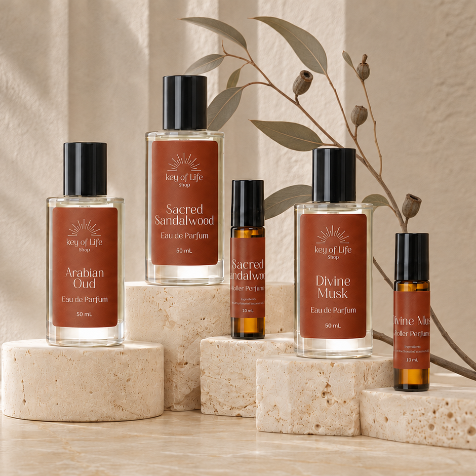 Four Melted Earth scented products in clear bottles with black caps and warm brown labels, arranged on stacked stone blocks against a softly lit beige backdrop with leafy branches.